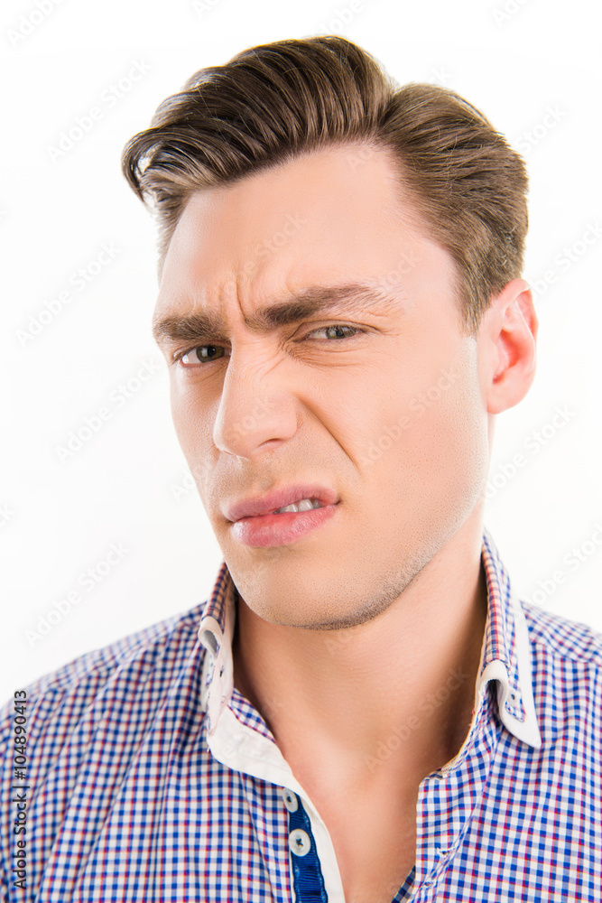 Close up photo of handsome man with unhappy grimace on his face Close up photo of handsome man with unhappy grimace on his face