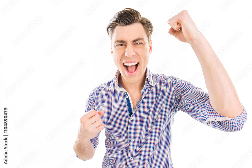 Yes! Handsome young businessman screaming and showing fists Yes! Handsome young businessman screaming and showing fists