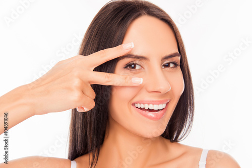 Cheerful healthy woman gesturing with two fingers near her eyes