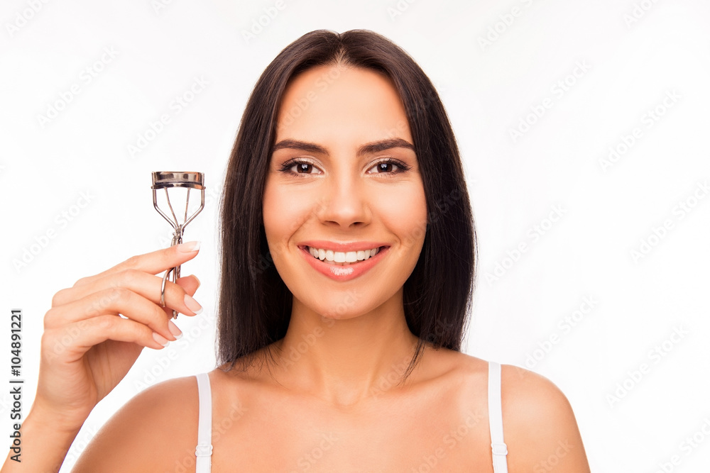 Close up portrait of smiling girl holding culer for eyelashes Close up portrait of smiling girl holding culer for eyelashes