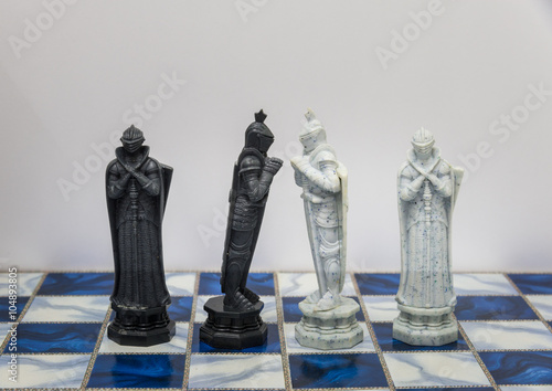 A pieces of chess character on the board with a light. A character represents strategy, planning, brave, betrayal, confrontation and competition. 