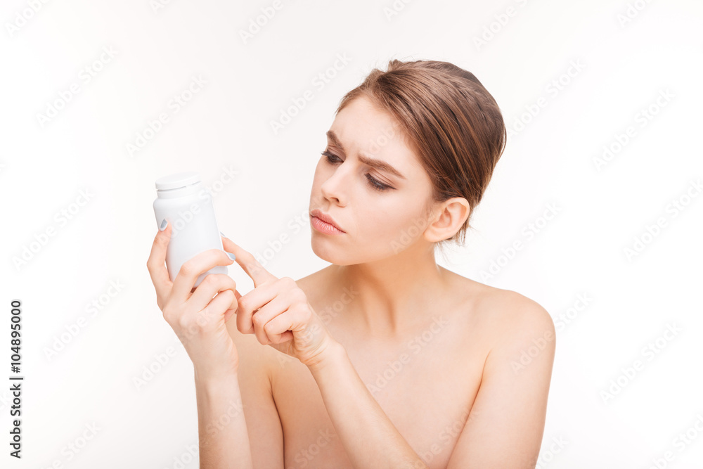 Woman reading chemical composition of pills Woman reading chemical composition of pills