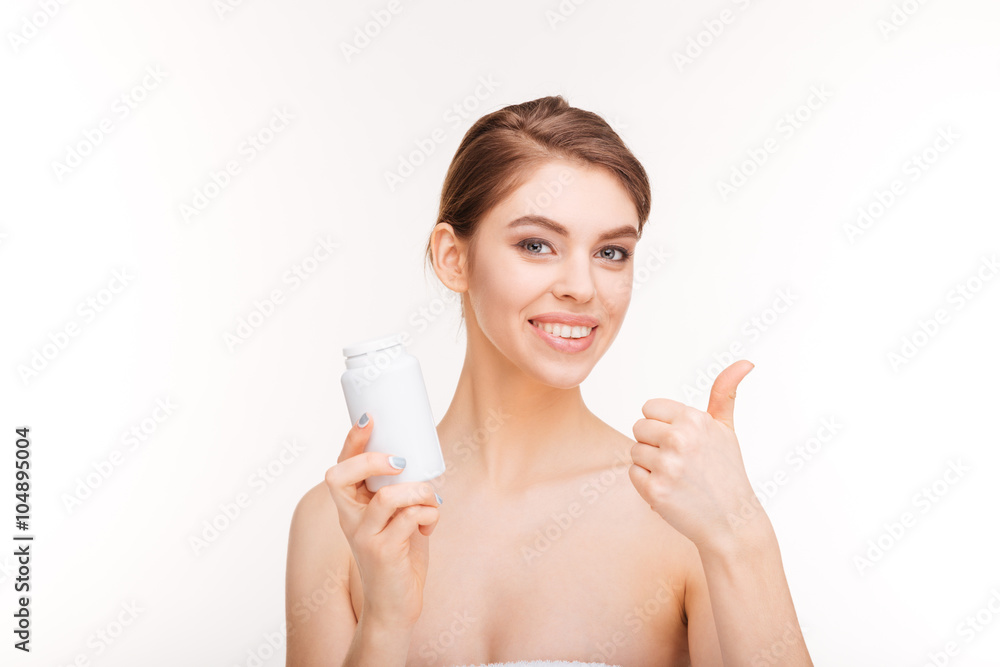 Woman holding bottle with pills and showing thumb up Woman holding bottle with pills and showing thumb up