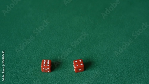 A hand of a man throwing two red dice on the green cloth. Slow motion. photo