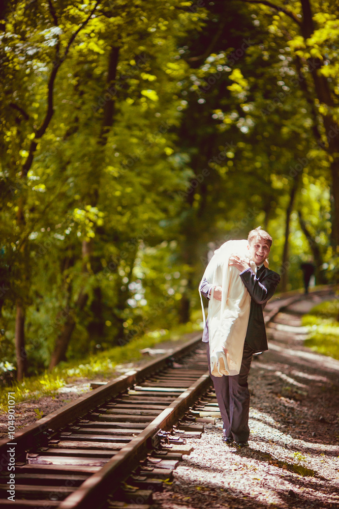 Happy newlywed romantic couple walking on rails in the park Happy newlywed romantic couple walking on rails in the park