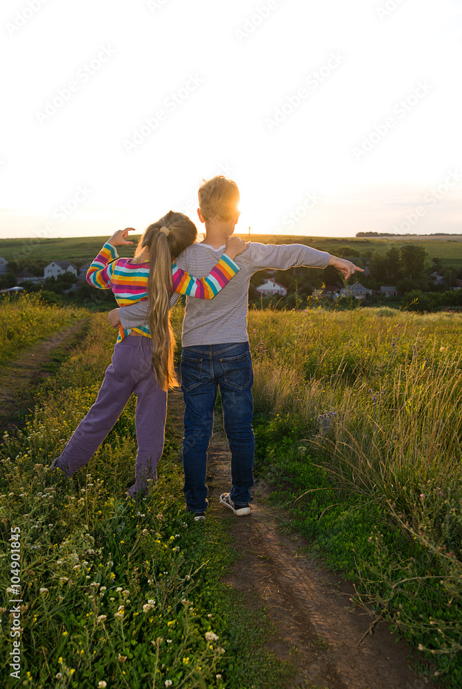 Boy and girl holding hands and walking along the road