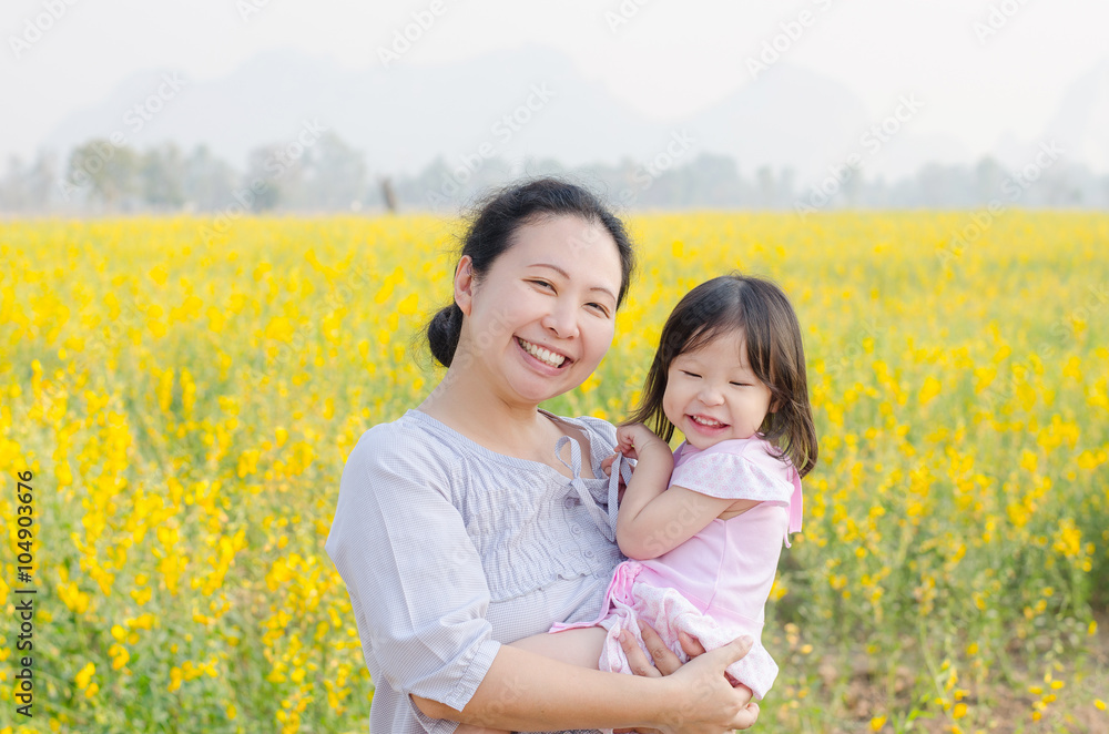 Asian mother and child smiling in flower field Asian mother and child smiling in flower field