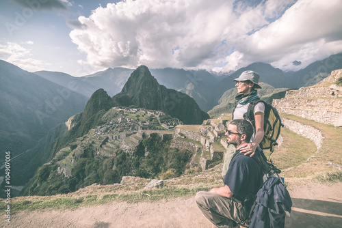 Hugging couple looking at Machu Picchu, Peru, toned image