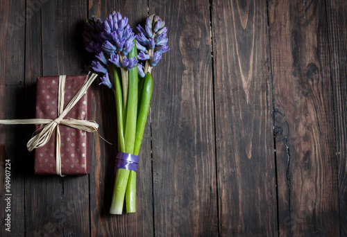 blue striped hyacinth flowers and present on wooden surface with copy space