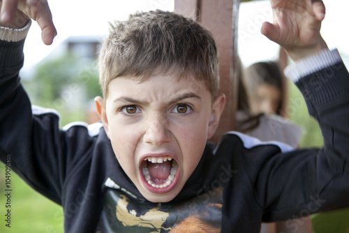 Bild auf Leinwand young boy is making face and gesturing with hands as if he is go
