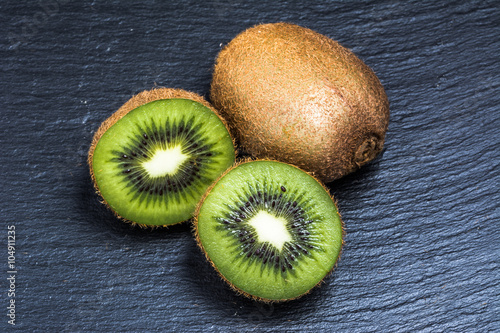 Halves of kiwi and whole kiwi macro.