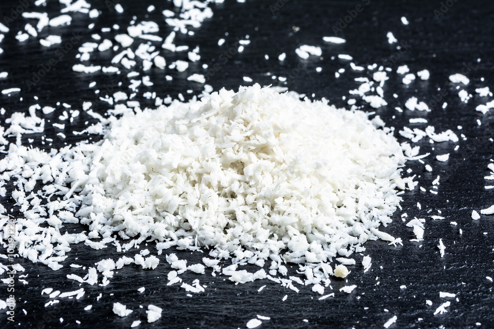 Coconut shreds isolated on black background, selective focus Coconut shreds isolated on black background, selective focus