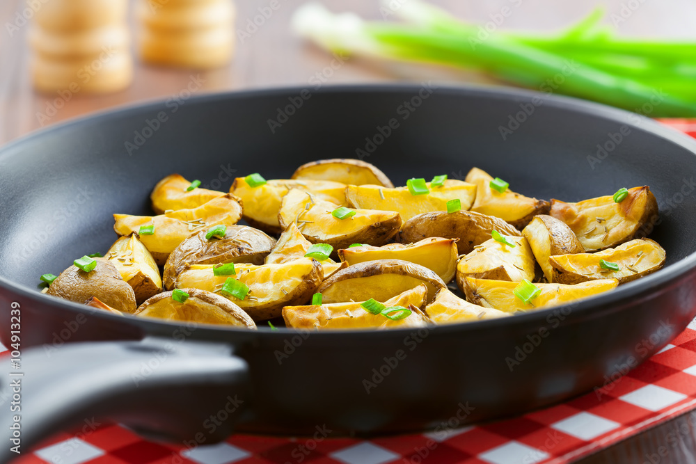 Delicious fried potato wedges on pan, homemade food, close-up Delicious fried potato wedges on pan, homemade food, close-up