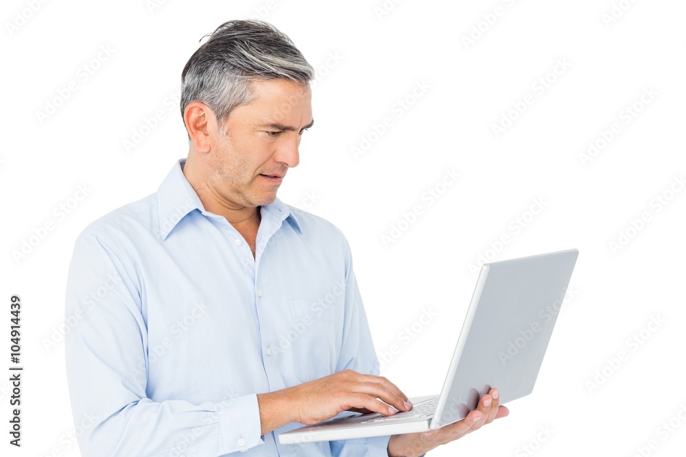 Smiling businessman typing on laptop