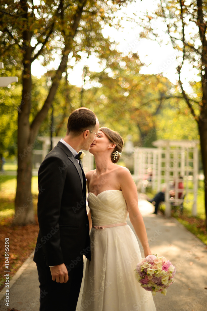 Beautiful bridal couple embracing in park Beautiful bridal couple embracing in park