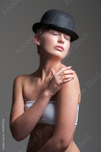 young lady posing in a black bowler hat  