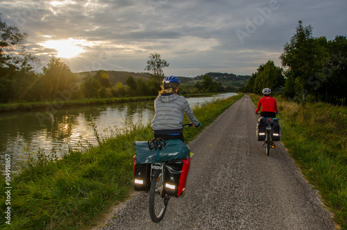 Burgundy, France - CIRCA August, 2015 - Two bikers with panniers cycling near Canal de Bourgogne photo