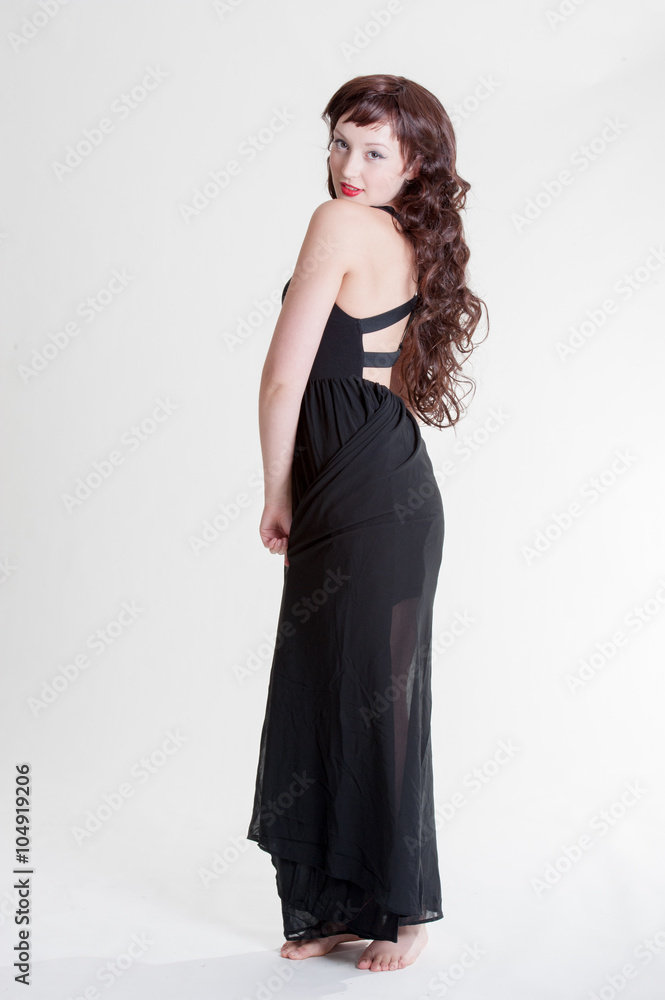 Young lady standing with a long black dress and long curly hair
Young lady standing with a long black dress and long curly hair