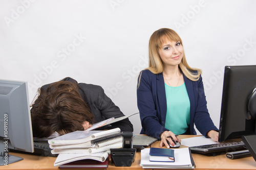 Vászonkép Female colleagues in the office, one had fallen asleep on a pile of folders, the