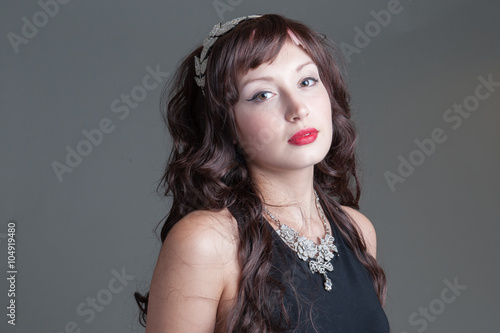 Young lady posing with long curled hair and jeweled leaves