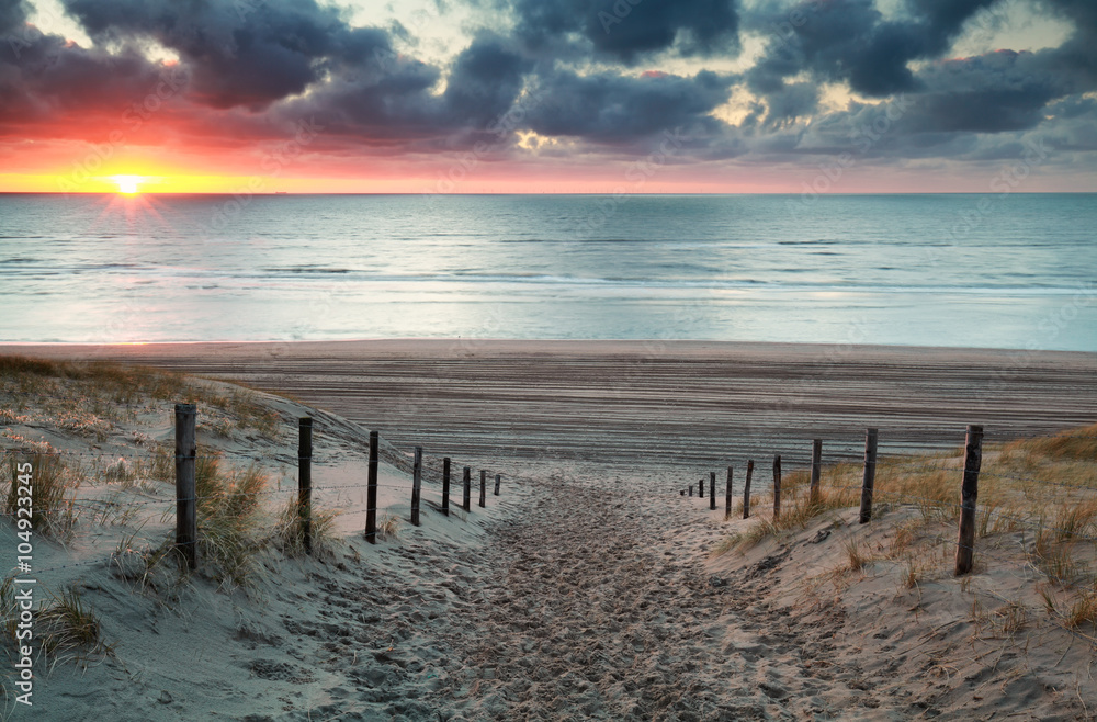 sand path to North sea beach at sunset
