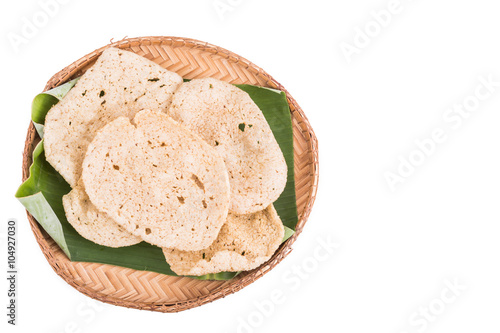 Freshy fried delicious fish crackers snack served on traditional rattan tray with white background