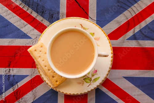 A cup of tea in a bone china cup and saucer on a union jack flag