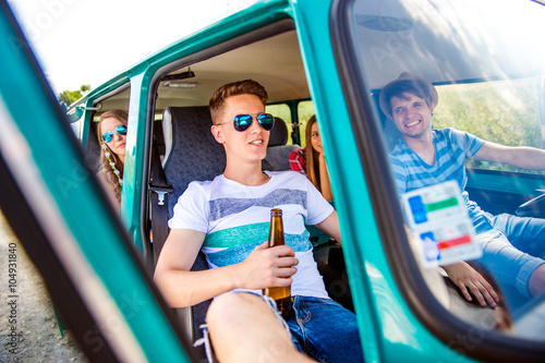 Teenagers inside an old campervan  drinking beer  roadtrip