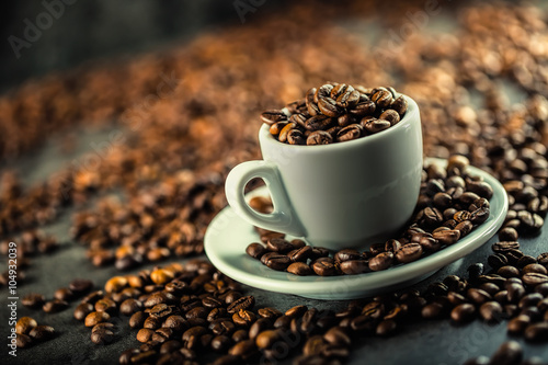 Coffee beans. Coffee cup full of coffee beans. Toned image.