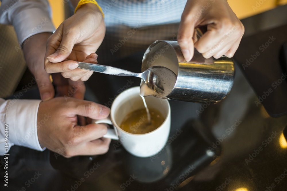 Waitress hands pouring milk making cappuccino Waitress hands pouring milk making cappuccino