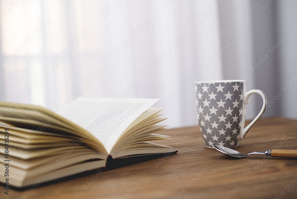 Cup of coffee with a book on wooden table. Cup of coffee with a book on wooden table.