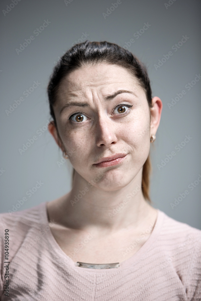 Fototapeta premium Woman is looking imploring over gray background