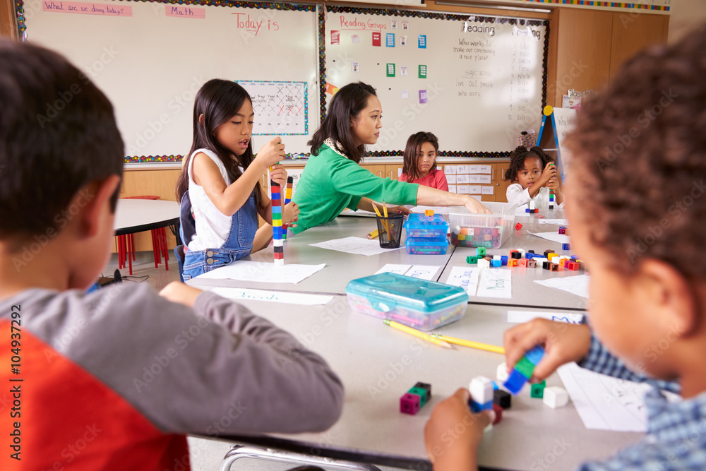 Fototapeta premium Elementary school teacher uses block play in class with kids