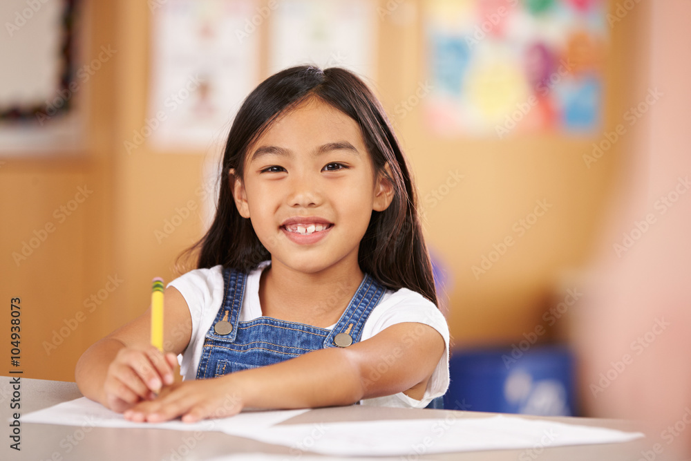 Portrait of a girl at elementary school sitting in classroom Portrait of a girl at elementary school sitting in classroom