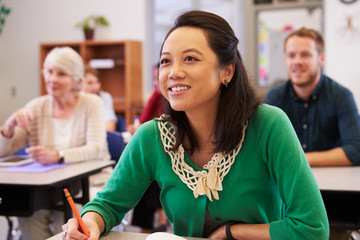 Asian woman looking at the board in an adult education class
