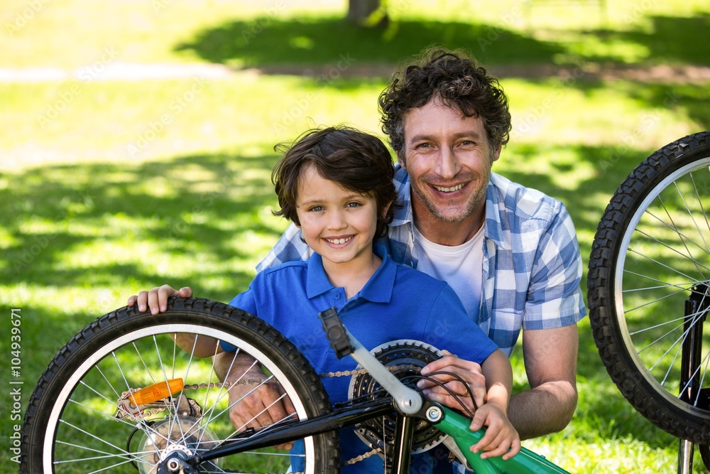 Obraz premium Father and son fixing the bike