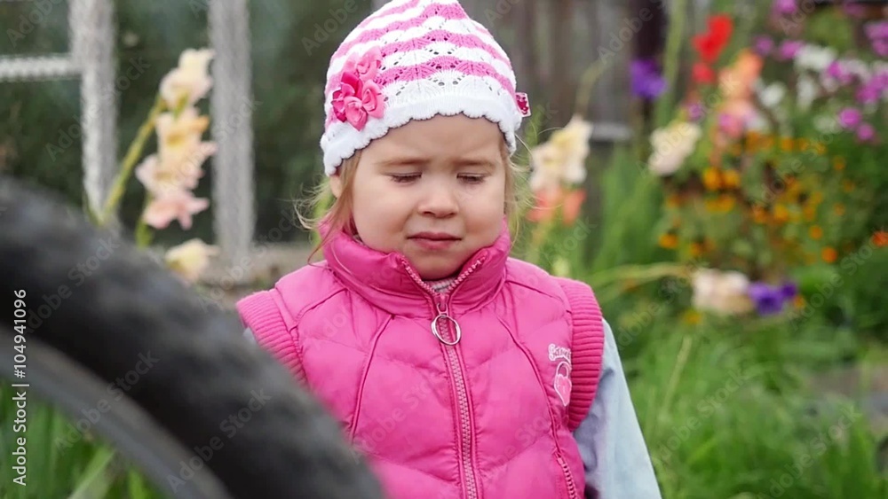 Small girl frowning and confused in the garden in slowmotion. 1920x1080 Small girl frowning and confused in the garden in slowmotion. 1920x1080