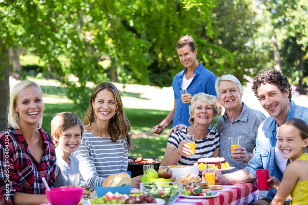 Family and friends having a picnic with barbecue Family and friends having a picnic with barbecue