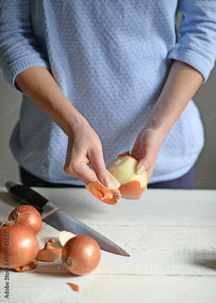 Woman hand cut fresh onion on white table Woman hand cut fresh onion on white table
