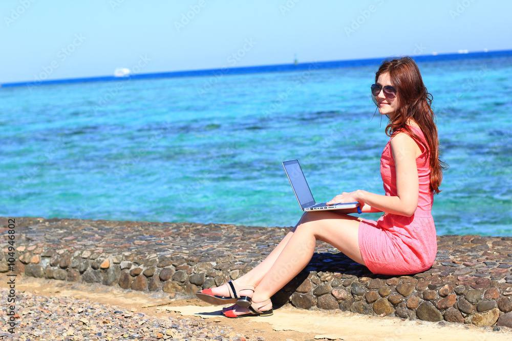 freelancer woman working on her laptop computer at the sea