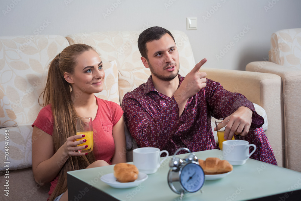 Cute young couple having breakfast, eating croissants, drinking orange juice. Cute young couple having breakfast, eating croissants, drinking orange juice.