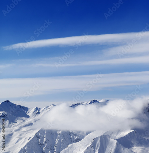 Snow mountains in clouds at sun day