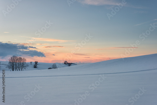 winter landscape at evening sunset and glowing sky clouds
