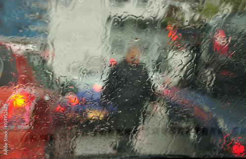Abstract urban view through the wet car windscreen under the rain. 