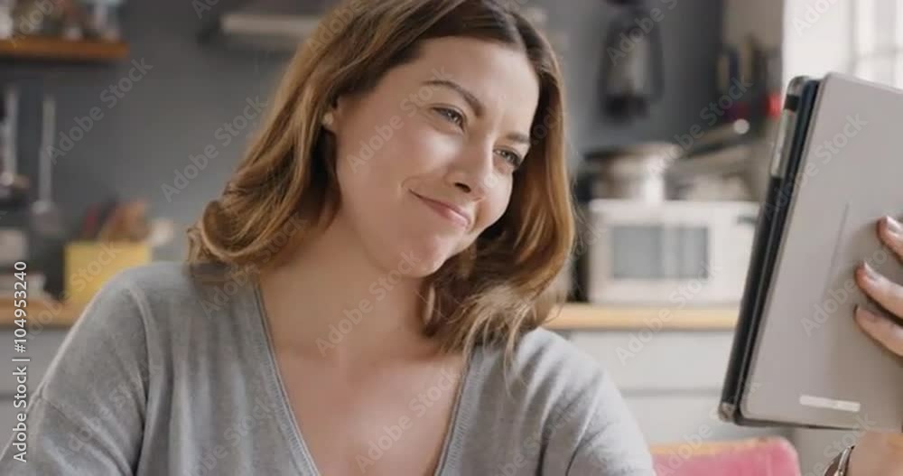 Beautiful woman talking to friends on internet using digital tablet app at home drinking coffee Beautiful woman talking to friends on internet using digital tablet app at home drinking coffee
