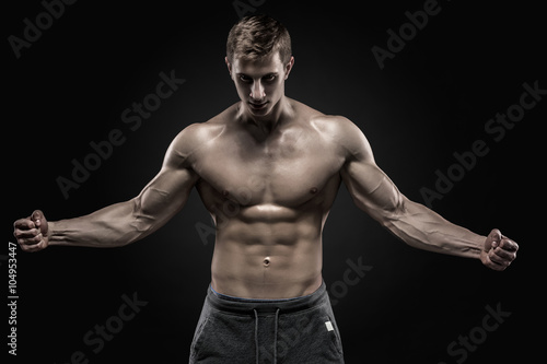 Stunning muscular man showing perfect abs, shoulders, biceps, triceps, chest 