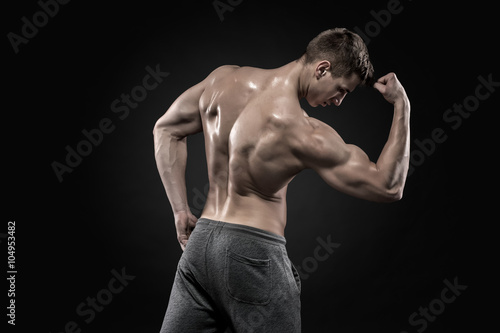 Healthy muscular man on showing perfect biceps, triceps, rear view 