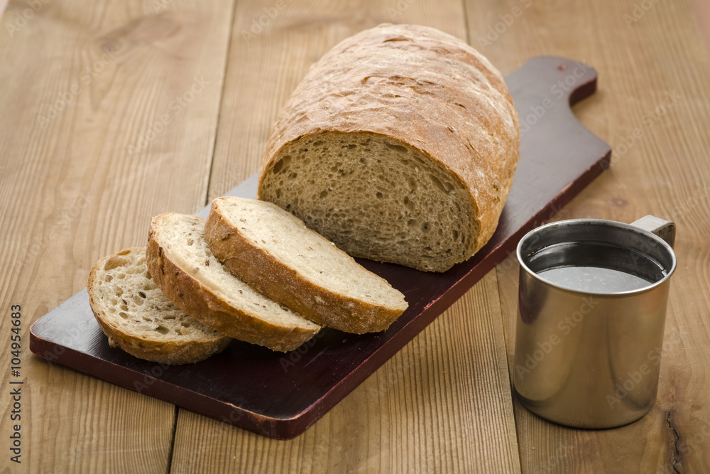 loaf of bread on a board and coffee