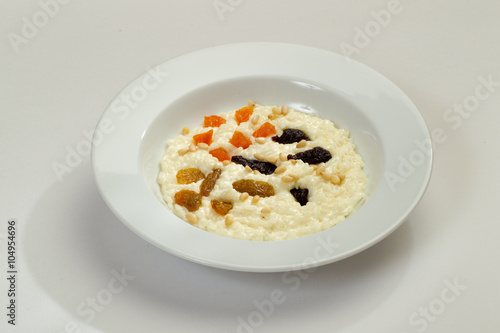 Oatmeal porridge in bowl topped with grapes and raisins.