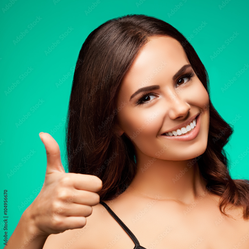 smiling young woman showing thumb up hand sign gesture, over gre smiling young woman showing thumb up hand sign gesture, over gre